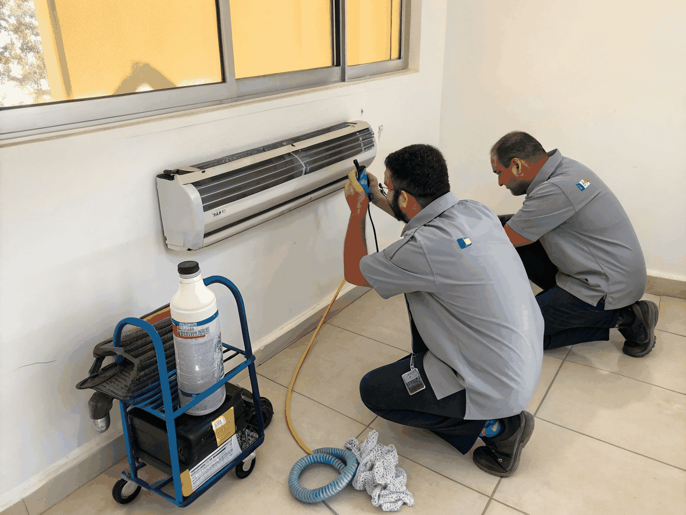 Aircon technician maintaining a home air conditioner in Singapore